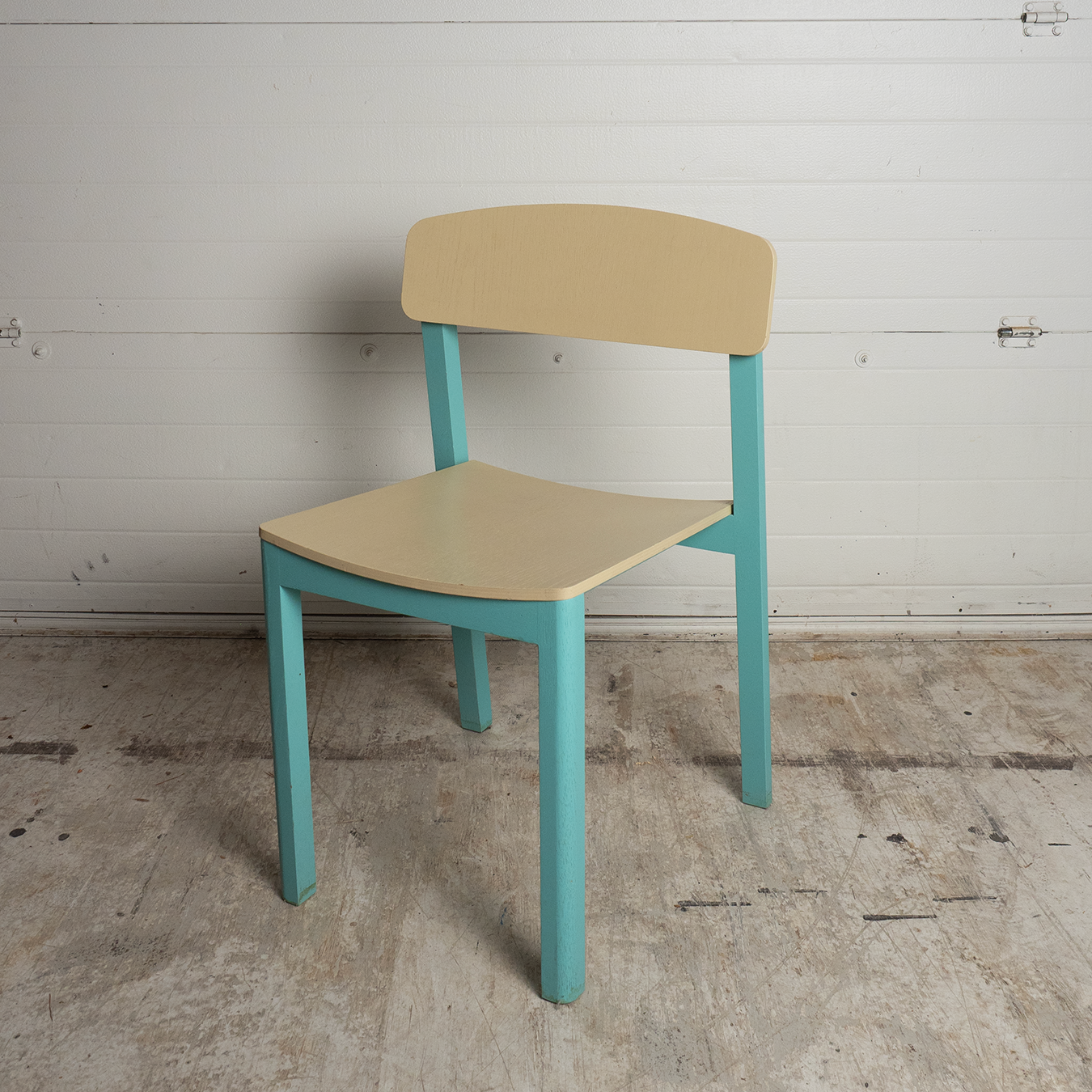 Diniong Chair with beige seat and backrest and blue legs against a white wall.